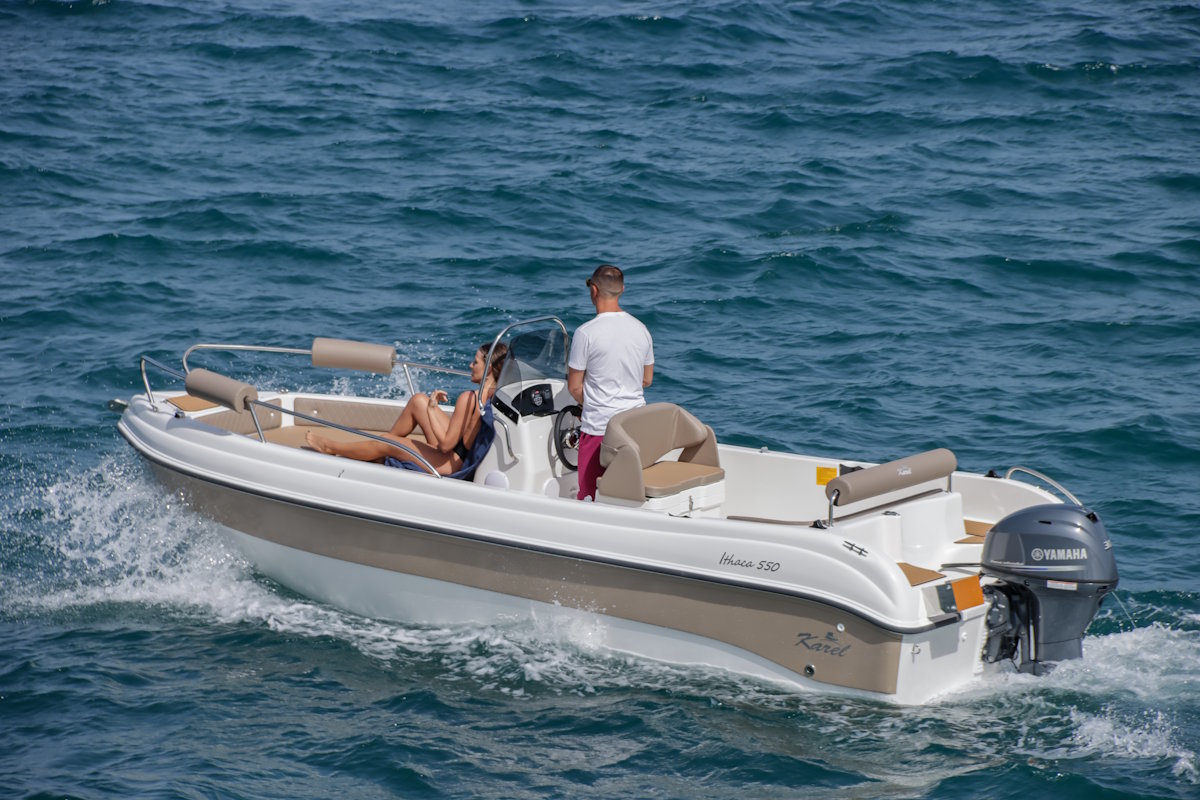 Couple driving a Carel Ithaca 550 self-drive boat on the Ionian Sea near Corfu